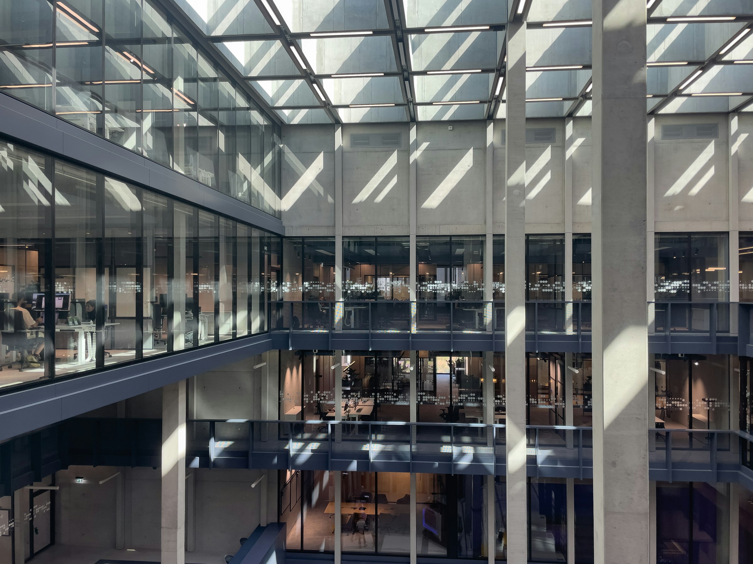 Modern office atrium with glass walls (photo: Bernd Dittrich / Unsplash)
